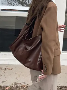Detail view of the soft brown leather tote bag, showcasing large capacity and lazy style.