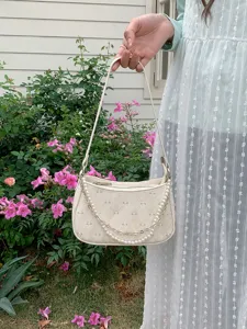 Elegant white baguette shoulder bag with chic pearl and chain strap, diamond lattice bow pattern.