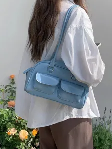 Detailed view of a stylish light blue patent leather shoulder bag with dual front pockets and metal hardware.