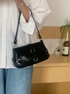 Black motorcycle shoulder bag for women, chic buckle underarm bag for casual everyday wear.