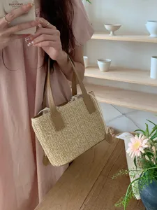 Detail shot of straw woven bucket bag with leather handles and drawstring, summer style.