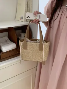 Summer straw woven bucket bag fashion casual beach handbag with PU leather handles and drawstring.