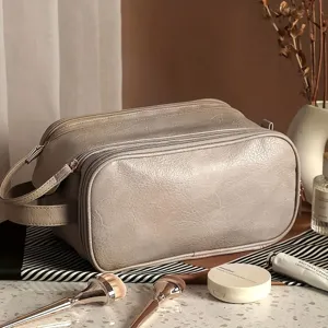 Detailed view of the large capacity grey travel cosmetic bag with double zipper and handle.