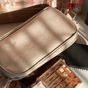 Large capacity beige cosmetic bag with textured finish, perfect travel makeup storage pouch.