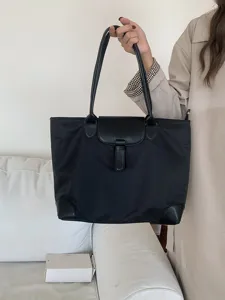 Black nylon tote bag for women, large capacity commuter shoulder bag with flap design.
