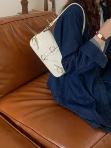 Close-up view of the white motorcycle style shoulder bag showcasing multiple strap buckles.