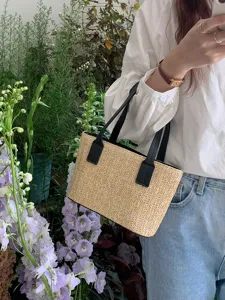 Detailed view of summer straw woven handbag with black PU leather handles and natural texture.