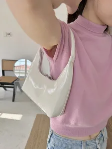 Vista dettagliata di una elegante borsa hobo bianca in pelle verniciata a mezzaluna per l'estate.