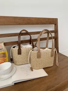Close-up detail of stylish woven bucket bags with leather handles and drawstring lining.