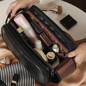 Large capacity black leather cosmetic bag with double zipper and multi compartments for travel.