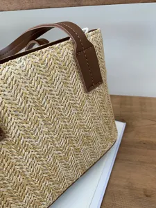 Woven straw detail of the summer vacation casual bucket handbag featuring brown leather handle.