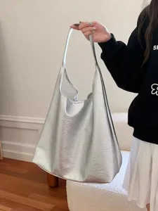 Silver metallic slouchy shoulder bag detail showing soft PU leather texture and large capacity.