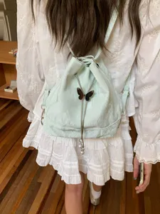 Mint green drawstring backpack for women, stylish bucket bag with cute butterfly pendant.