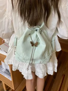 Mint green bucket backpack for women, stylish casual shoulder bag with metal butterfly.