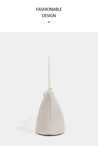 Detail view of minimalist beige soft leather shoulder bucket bag, side profile showing clean lines.