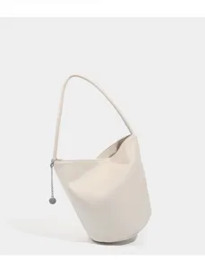 Soft leather bucket bag detail view featuring minimalist style, shoulder strap and metal chain.