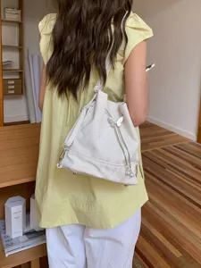 Stylish white backpack bucket bag with cute butterfly pendant, trendy daily casual shoulder bag.