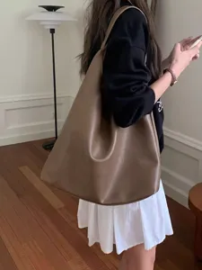Detail shot of a brown slouchy leather shoulder tote bag, minimalist style, stylish look.