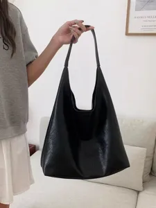 Detailed view of the large black slouchy hobo shoulder bag held in hand, showing soft texture.