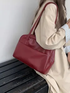 Detailansicht einer weinroten Vintage-Ledertasche mit großem Stauraum und praktischer Vordertasche.
