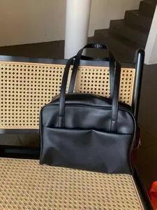 Detailansicht der schwarzen Ledertasche mit großem Fassungsvermögen und elegantem Design.