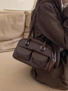 Dark brown patent leather shoulder bag detail, stylish daily handbag with front pocket hardware.