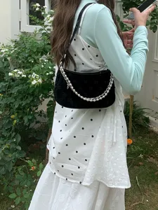 Stylish black women underarm shoulder bag with elegant pearl and metal chain straps.