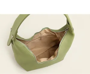 Detailed interior view of light green leather hobo bag showing lining, zipper, and pocket.