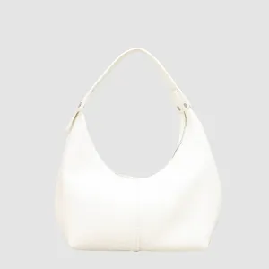 Minimalist white pebbled leather underarm bag detail, sleek crescent shape handbag.
