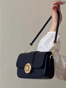 Detail view of the black leather shoulder bag featuring exquisite gold-tone ornate clasp and strap.