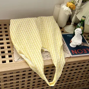 Detailed close-up of the yellow and white plaid fabric tote bag styled in a cozy aesthetic scene.