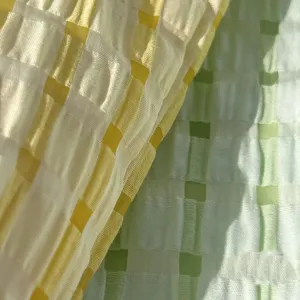Close-up fabric detail showing mint green and yellow checkered textured material pattern.