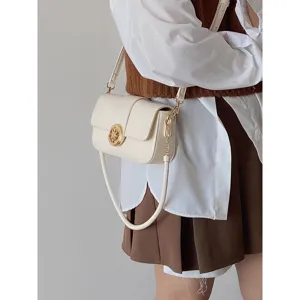 Close-up of a chic white faux leather shoulder bag with gold metal clasp detail in daily wear.