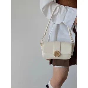 Classic vintage style shoulder bag detail shot, chic cream white leather with gold clasp.