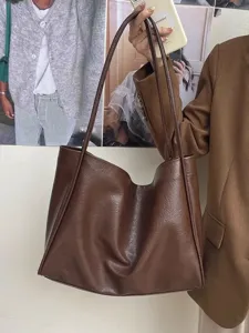 Close-up of the dark brown soft leather tote bag detail, showing soft texture and large capacity.