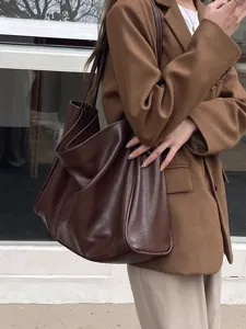 Detail shot of a dark brown slouchy tote bag, soft leather shoulder bag for women daily use.