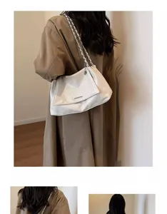 Detail view of a stylish white leather underarm bag with silver chain strap, perfect for women.