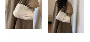 Detail view of stylish chic women underarm shoulder bag with metal chain strap and white finish.