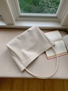 Cream white faux leather tote bag detail view, soft shoulder bag lifestyle aesthetic display.