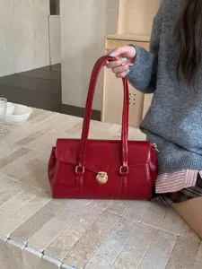 Elegant red leather handbag and shoulder bag for women, featuring chic gold-tone hardware.