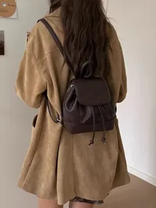 Chic brown mini backpack for women, stylish faux leather daypack with drawstring and flap closure.