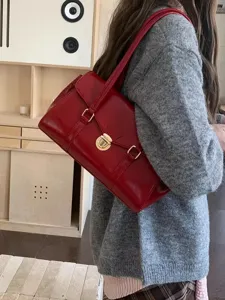Elegant red shoulder bag for women with shiny leather and chic metal lock design.