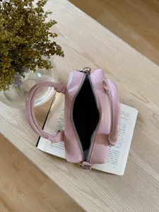 Pink retro bowling handbag with dual top handles and zipper closure for daily commute.
