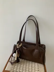 Vintage brown baguette shoulder bag with double straps and cute baseball charm pendant.
