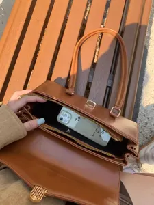 Vintage style brown PU leather handbag detail showing spacious interior capacity for daily use.