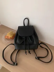 Stylish black mini leather backpack for women, cute casual drawstring daily school book bag.