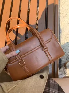 Retro brown leather briefcase handbag for women, elegant commuter tote bag with handles.