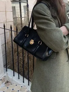 Retro minimalist black underarm tote bag for women, elegant commuter handbag with gold lock detail.