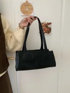 Detailed shot of a black PU leather vintage underarm baguette shoulder bag for women.