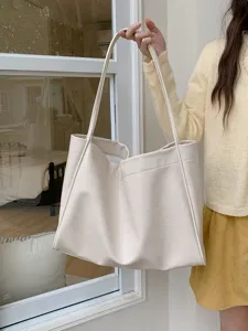 Detail view of large capacity soft leather tote bag in cream, stylish casual commuter shoulder bag.